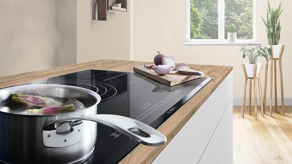 A stainless steel cooking pot simmering with vegetables.