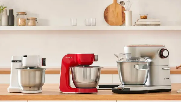 Three Bosch kitchen machines of different sizes lined up on a kitchen counter.