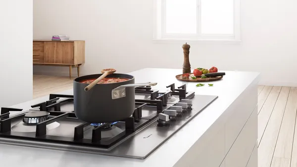 A black cooking pot with a simmering stew in a bright and modern kitchen.