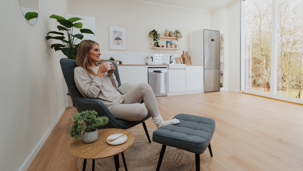 Une fille se d&eacute;tend avec une tasse de caf&eacute; dans un espace moderne et lumineux.