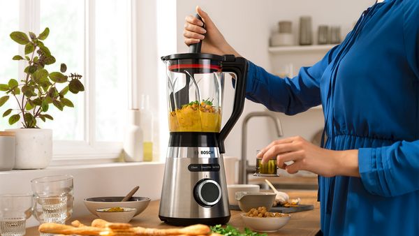 Eine Frau zerkleinert Kichererbsen f&uuml;r Hummus im Bosch Standmixer.