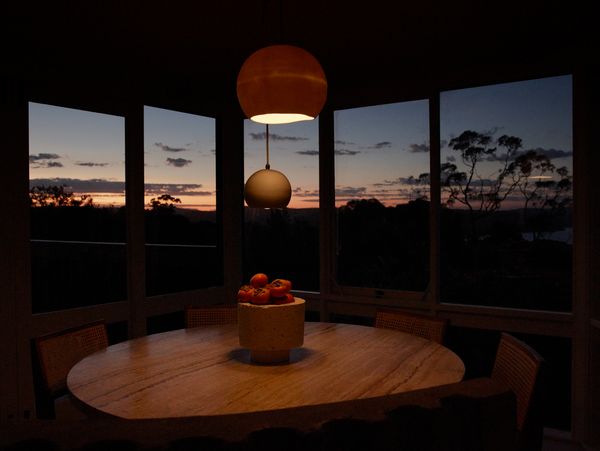 A dual aspect view looking across the dining room table at a beautiful Australian sunset