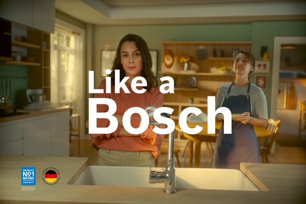 Электрический духовой шкаф Series 8 от Bosch на кухне. На столешнице перед ним лежит различная выпечка, такая как морковный пирог и кексы.
