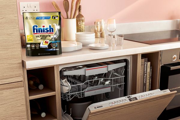 Dishwasher with door open and Finish tablets sat above