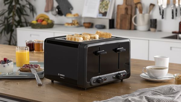 DesignLine 4-slice toaster on the kitchen table, surrounded by hot drinks.