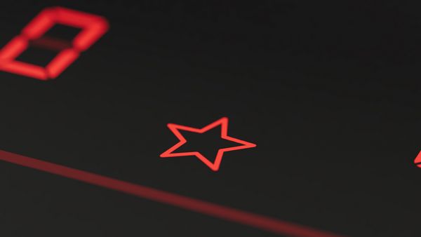 Ikona w kształcie czerwonej gwiazdki na pulpicie obsługi płyty grzewczej.