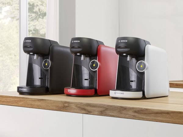 Die TASSIMO FINESSE friendly Kapselmaschine in unterschiedlichen Farben auf einer Küchenarbeitsplatte.