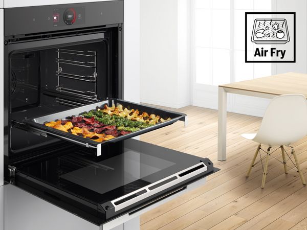 Forno Bosch aperto con una teglia di verdure ben cotte e croccanti