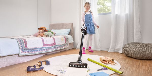 Child using Unlimited vacuum to clean room