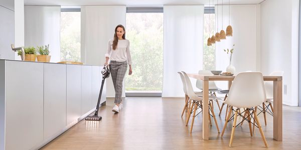 Person using Bosch vacuum on laminate flooring