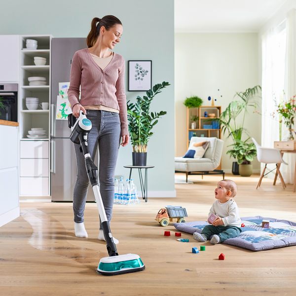 Person using unlimited 7 aqua whilst baby plays on floor