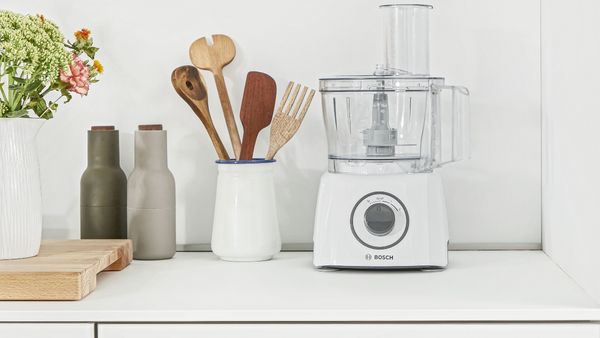 Bosch food processor next to an array of tools and ingredients.