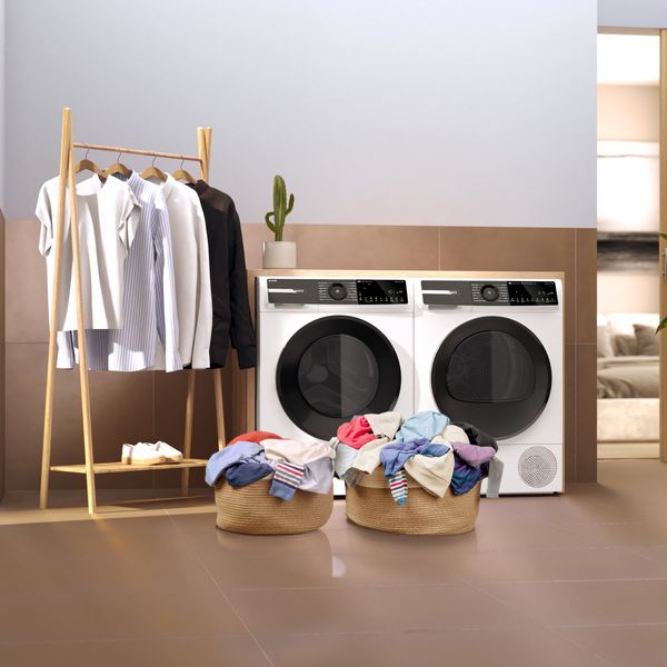 Ceste di panni pronte per il bucato, davanti a una lavatrice a un’asciugatrice