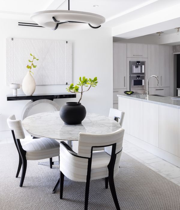 The cleanly designed dining room in Jonathan Savage’s stylish Ibis Isle condominium in Palm Beach, with a Gaggenau wine cabinet and the kitchen full of Gaggenau appliances.