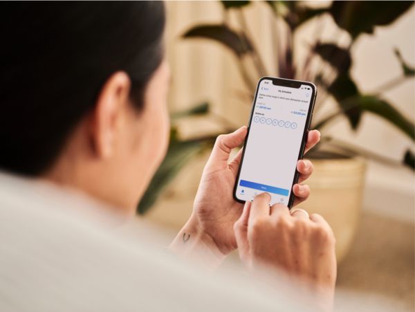 Persona che utilizza uno smartphone con app Bosch per gestire il lavaggio