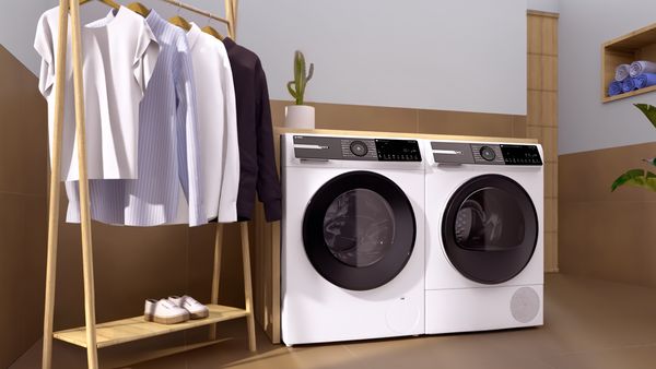 Bosch Hausgeräte der Serie 6 stehen in einem Waschraum neben einem Wäscheständer mit Hemden.