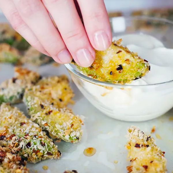 Dipping finished avocado fries in sauce