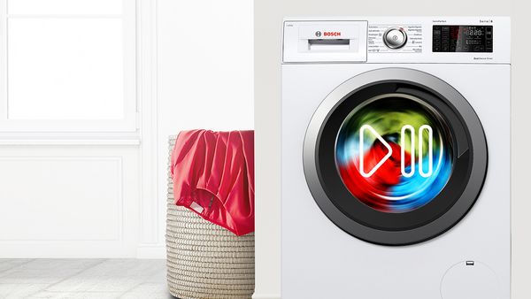 Colourful clothes spinning inside a Bosch washing machine.