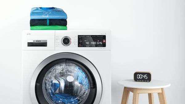 Timer next to a Bosch washer set to time a 45-minute quick wash programme.