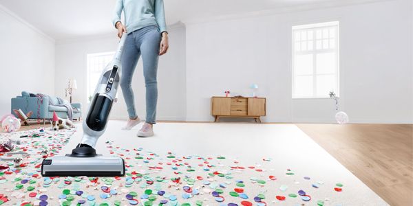 Woman vacuuming white carpet