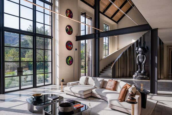 A wide angle photograph showing the luxurious lounge interior, stairs and view onto the garden