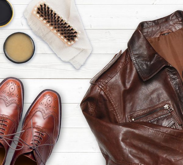 Giacca e scarpe in pelle con utensili per la pulizia