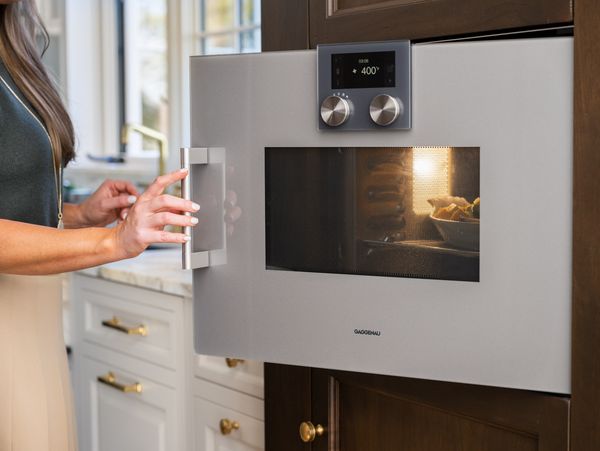 Close-up view of Lauren opening a Gaggenau 200 series oven