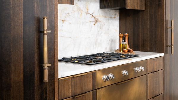 Close-up of the brass burners on the Gaggenau cooktop and matching fixtures