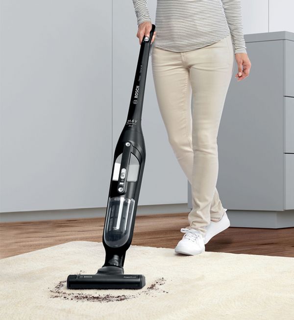 Person vacuuming dirt on rug