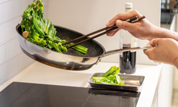 Person cooking in pan on bosch induction hob