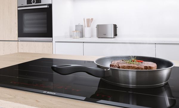 pan on an induction hob with Bosch appliances in the background