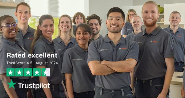 A group of Bosch Service Technicians standing in a kitchen, all facing forward.