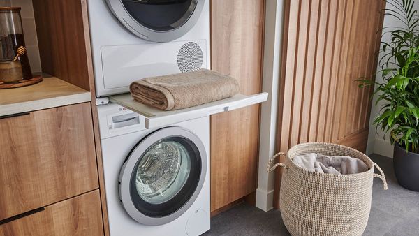 Une tour de lavage de Bosch est intégrée dans une armoire en bois brun.