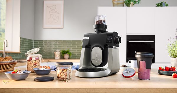 Cucina controsoffitto con prodotti di prep cibo, mixer stand, e ripiani con utensili da cucina. 