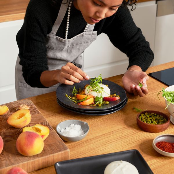 Giovane donna che prepara un piatto gourmet a casa