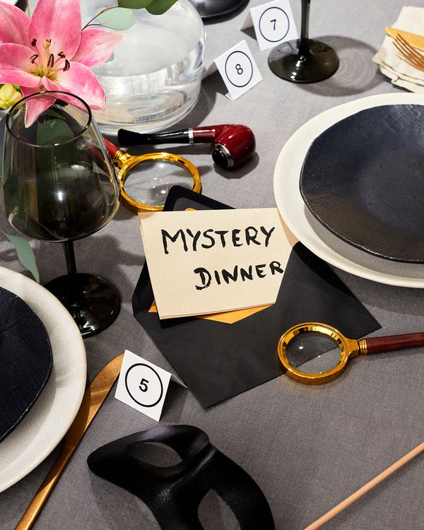 Bigliettini di indizi su una tavola apparecchiata per una cena a tema