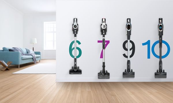 Soggiorno con quattro scope elettriche Bosch Unlimited senza filo appese alla parete, con indicazione dei numeri di modello 6, 7, 9 e 10.