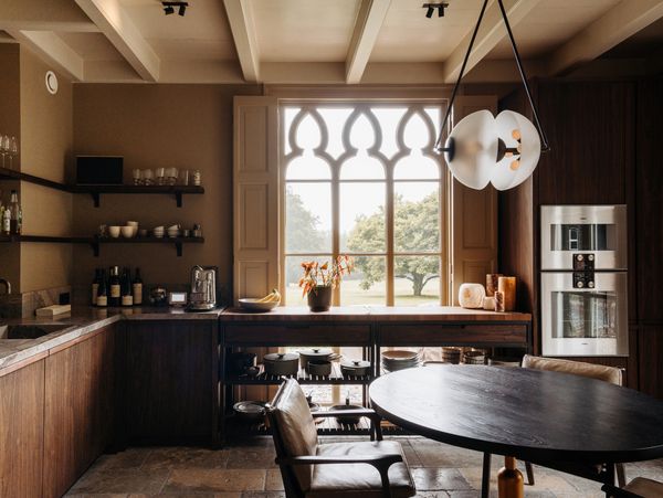 View across the kitchen looking outside, showing Gaggenau appliances and period window detail