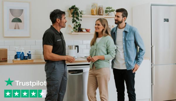 Bosch engineer speaking with two customers in a kitchen