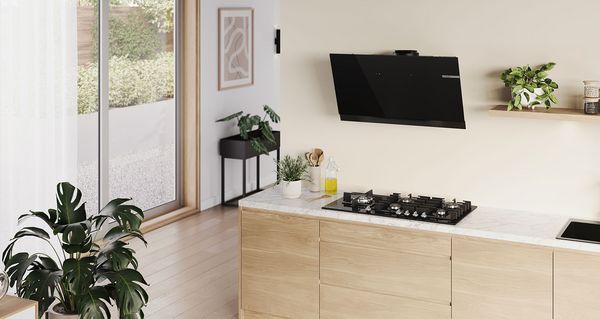 Vue d'ensemble d'une belle cuisine moderne encastrée avec une plaque de cuisson à gaz Serie 8 et une hotte inclinée.