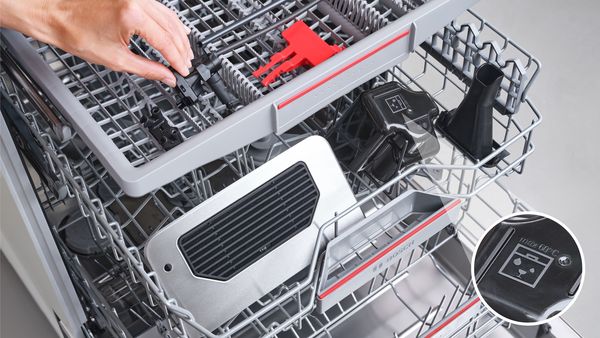 Κάποιος τοποθετεί εξαρτήματα της μηχανής καφέ στο πλυντήριο πιάτων, δείχνοντας ότι είναι κατάλληλα για το πλυντήριο πιάτων.