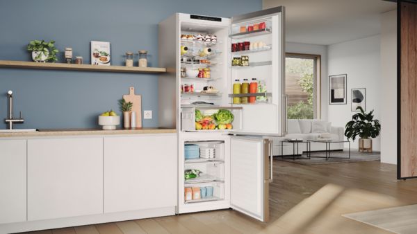 An open refrigerator in a kitchen, showcasing its interior filled with various food items and beverages.