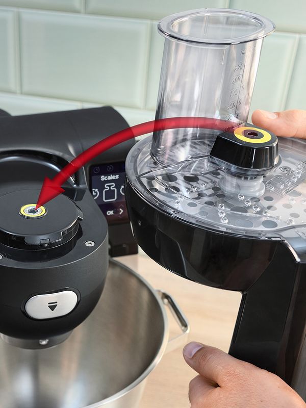 Person holding citrus press attachment with yellow colour coding, arrow pointing to corresponding yellow part on top of Series 6 stand mixer.
