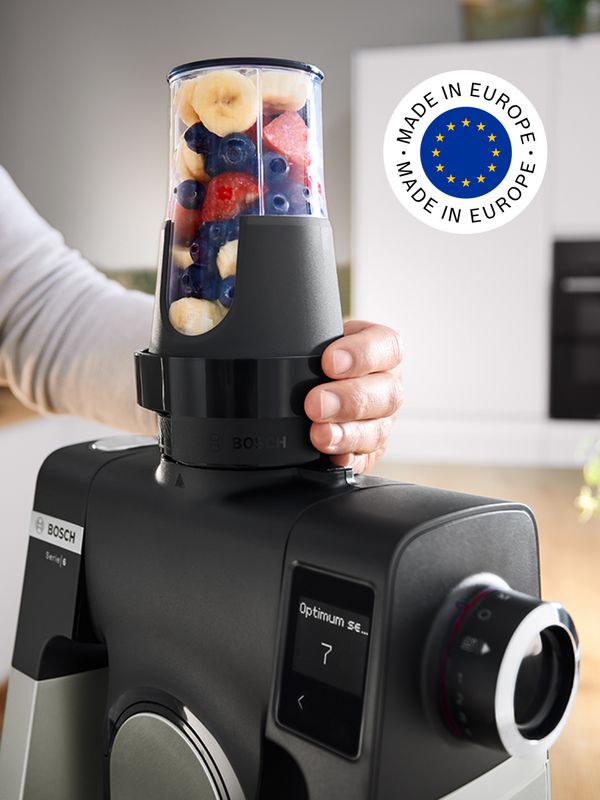 Person using ToGo bottle to make fruit smoothie with Series 6 stand mixer and 'made in Europe' logo in picture.