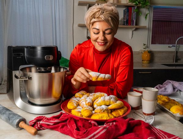 Julstämning i kök med Zeina och saffransgifflar. Hon har på sig en röd vacker julblus.