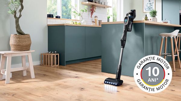 Der kabellose Handstaubsauger Unlimited 10 in schwarz steht angelehnt an einen modernen Küchenblock.