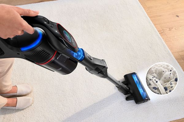 Person using vacuum with zoomed section showing dirt on microfibres