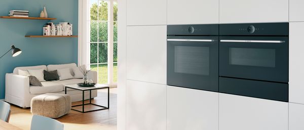 A Bosch convection oven in the foreground of a bright modern dining room.