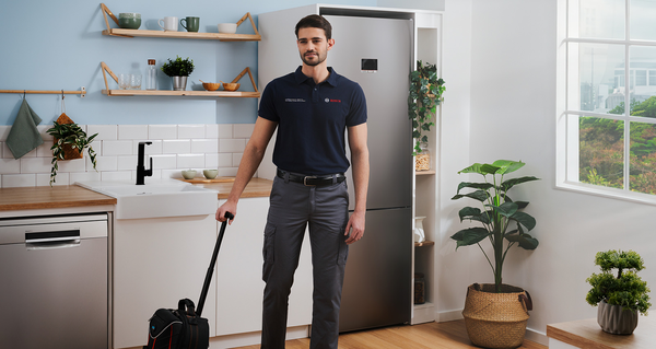 Technicien Bosch dans une cuisine moderne avec un sac &agrave; outils.