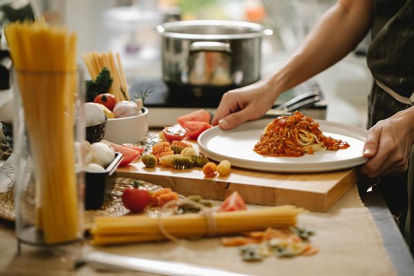 Osoba przygotowuje spaghetti w kuchni 